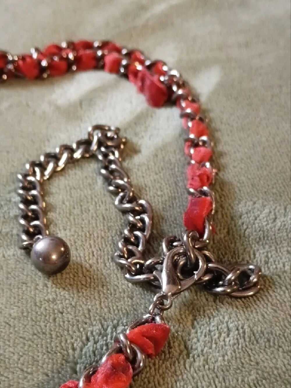 Multi Strand Necklace Featuring Interwoven Ribbon Centered Around Ornate Floral